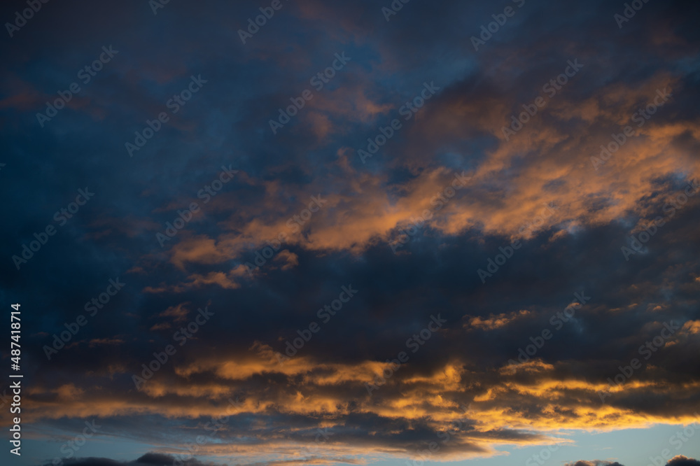Dense dramatic painted clouds at sunset of the day against a blue sky