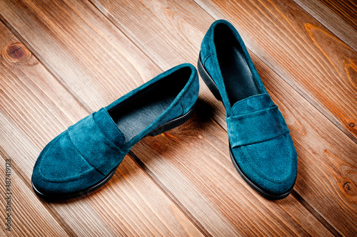 Suede dark green women's slip-on shoes with a small heel. Close-up shot.
