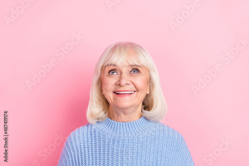 Photo of aged cheerful lady look empty space guess imagination dream isolated over pink color background