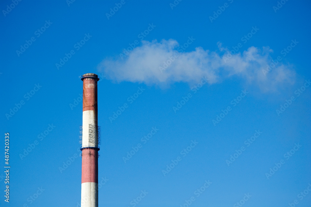White smoke from the boiler room chimney against the blue sky. White smoke from the boiler room chimney against the blue sky.