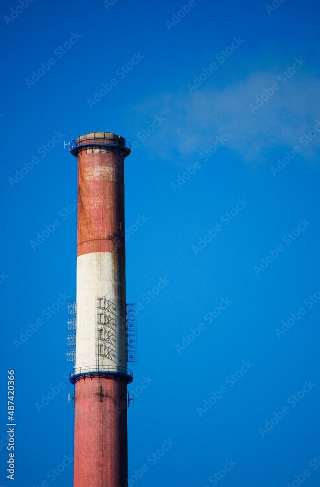 White smoke from the boiler room chimney against the blue sky.