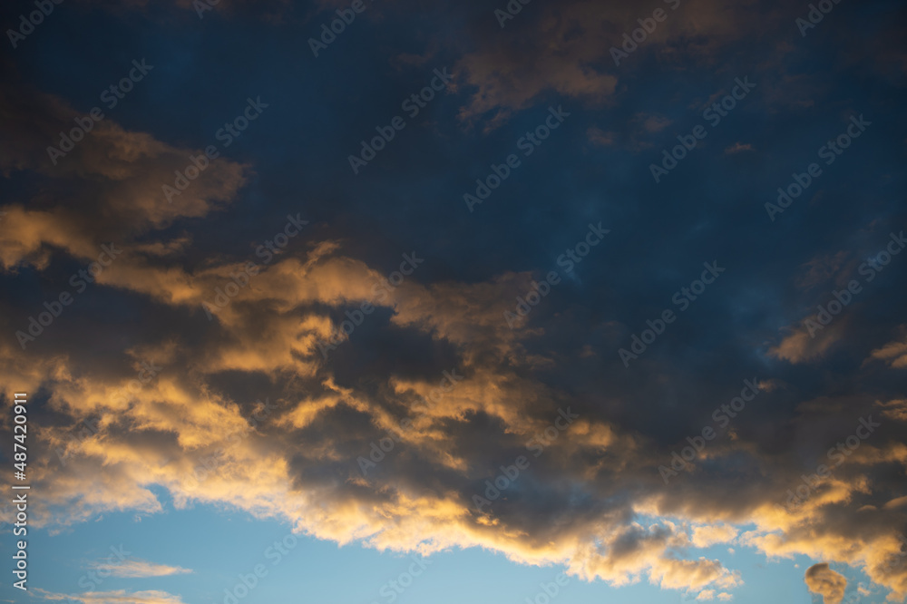 Fototapeta premium Thick clouds at sunset against a blue sky