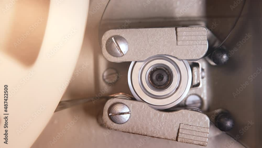 Close-up detailed view of working process retro old-fashioned 8mm projector playing reels with tape film. Coil turning. Vintage objects, entertainment, nostalgia, festival equipment Close-up detailed view of working process retro old-fashioned 8mm projector playing reels with tape film. Coil turning. Vintage objects, entertainment, nostalgia, festival equipment