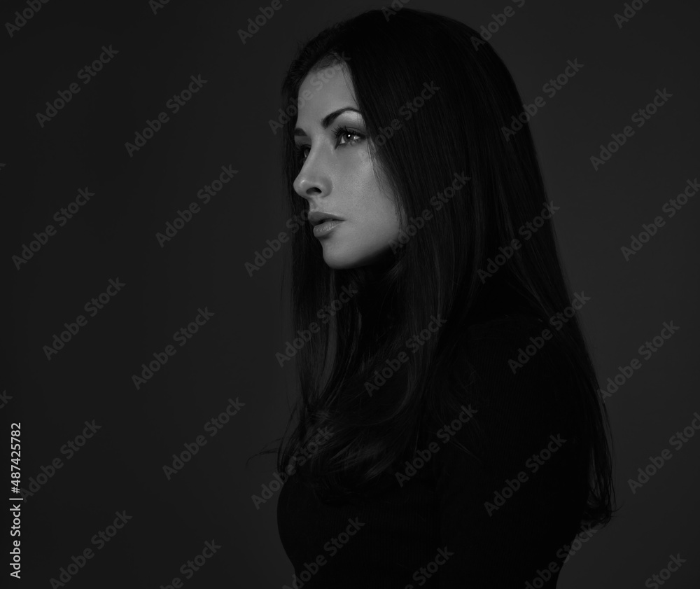 Business strong thinking woman find the answer in clever mind in black polluver on dark shadow black background. Closeup profile view face portrait. Black and white.