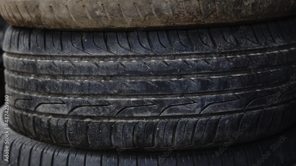 dirty old car tires stacked on the floor