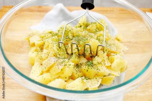 Mashing Boiled Potatoes in a Glass Bowl photo