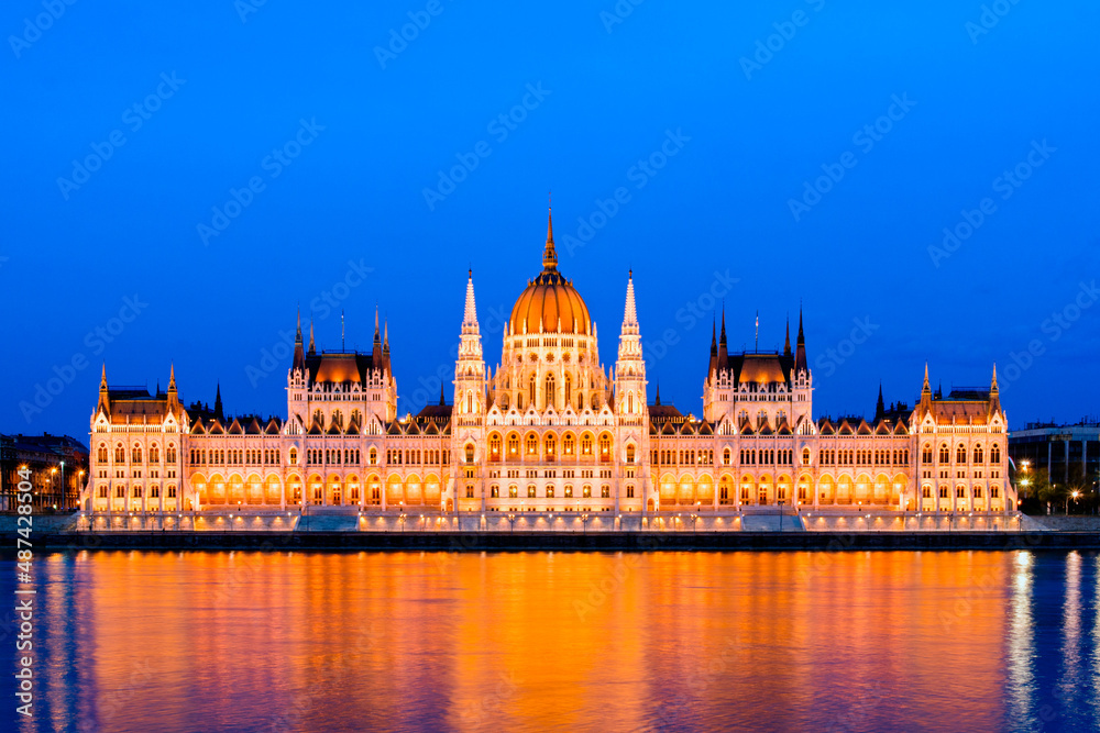 Illuminated parliament building in Budapest, Hungary, in the evening - Parliament in Budapest illuminated at dusk