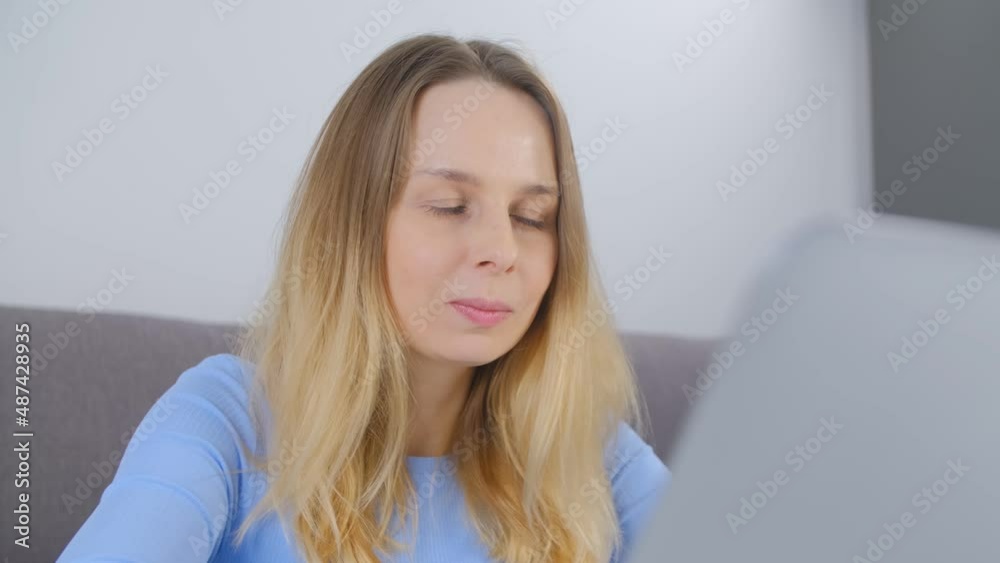 Cheerful white woman working on notebook pc at home. Entrepreneur person doing distant work on modern laptop. Freelance writer female writing a book on computer in apartment during lockdown Cheerful white woman working on notebook pc at home. Entrepreneur person doing distant work on modern laptop. Freelance writer female writing a book on computer in apartment during lockdown