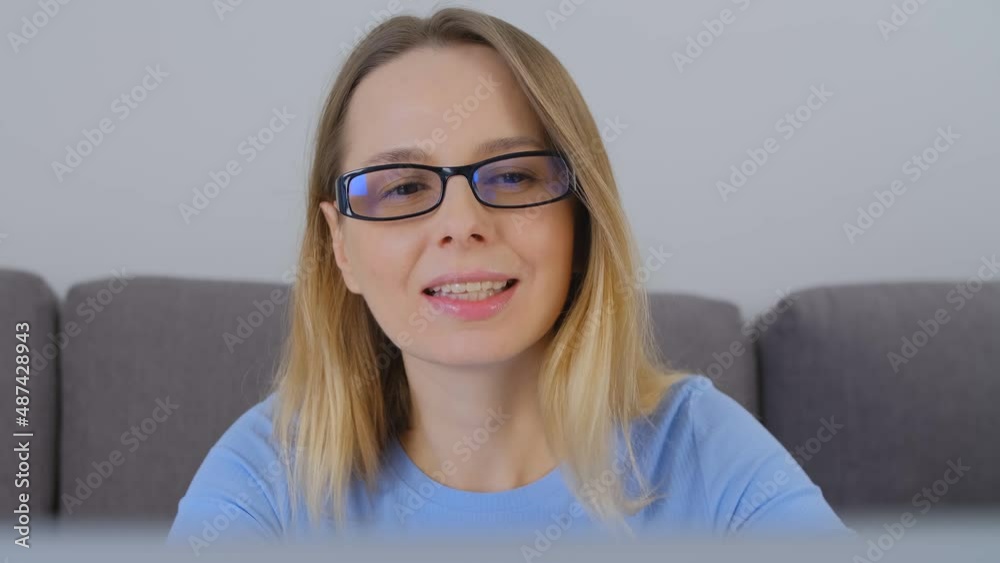 Smiling businesswoman working on computer. Video portrait of cheerful female in glasses doing distant work on notebook pc. Beautiful adult blonde writing text on modern laptop at home Smiling businesswoman working on computer. Video portrait of cheerful female in glasses doing distant work on notebook pc. Beautiful adult blonde writing text on modern laptop at home