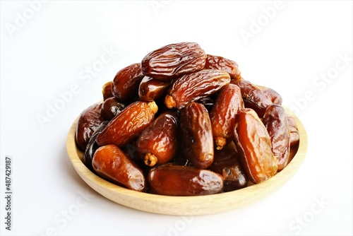 dried dates in a wooden plate photo isolate on white background top view copy space 