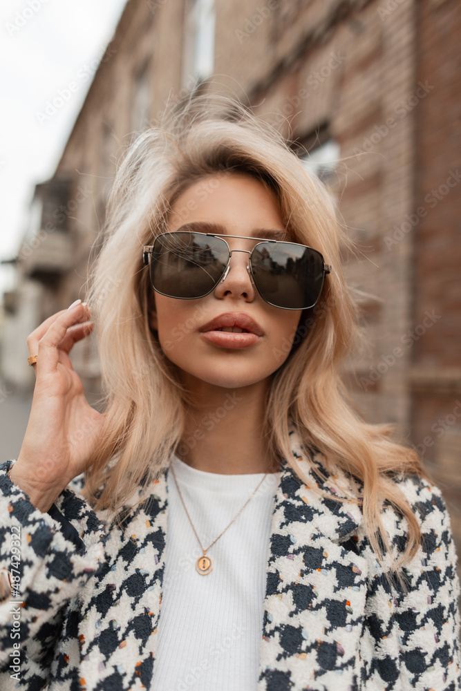 Urban female portrait of a beautiful sexy woman with glasses and big lips in a fashionable coat walking in the city Urban female portrait of a beautiful sexy woman with glasses and big lips in a fashionable coat walking in the city