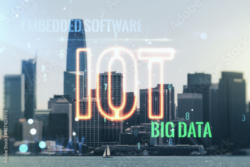 Double exposure of abstract virtual IOT hologram on San Francisco city skyscrapers background, research and development concept