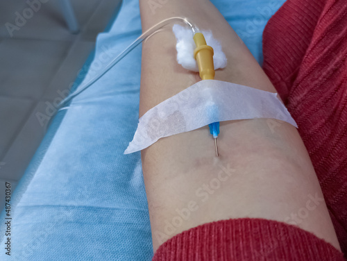 Hand with dropper needle and anesthesia injection.