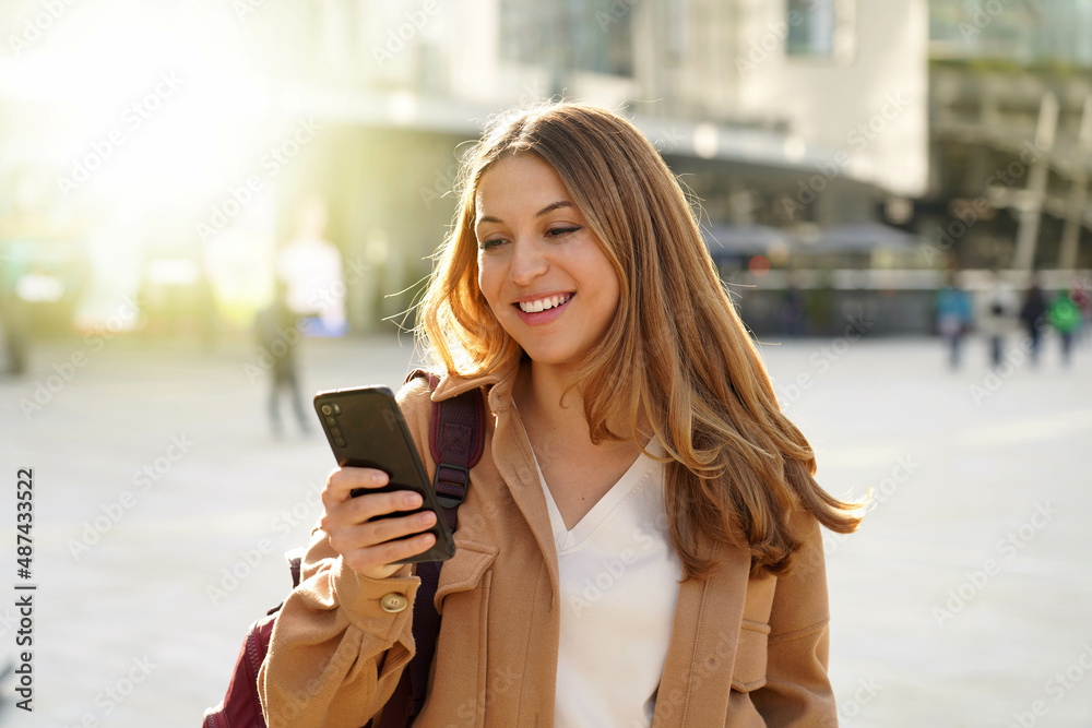 Surprised student girl watching excited her smartphone in city street