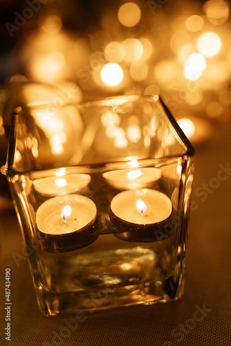 burning candles on a dark night in a wooden lantern
