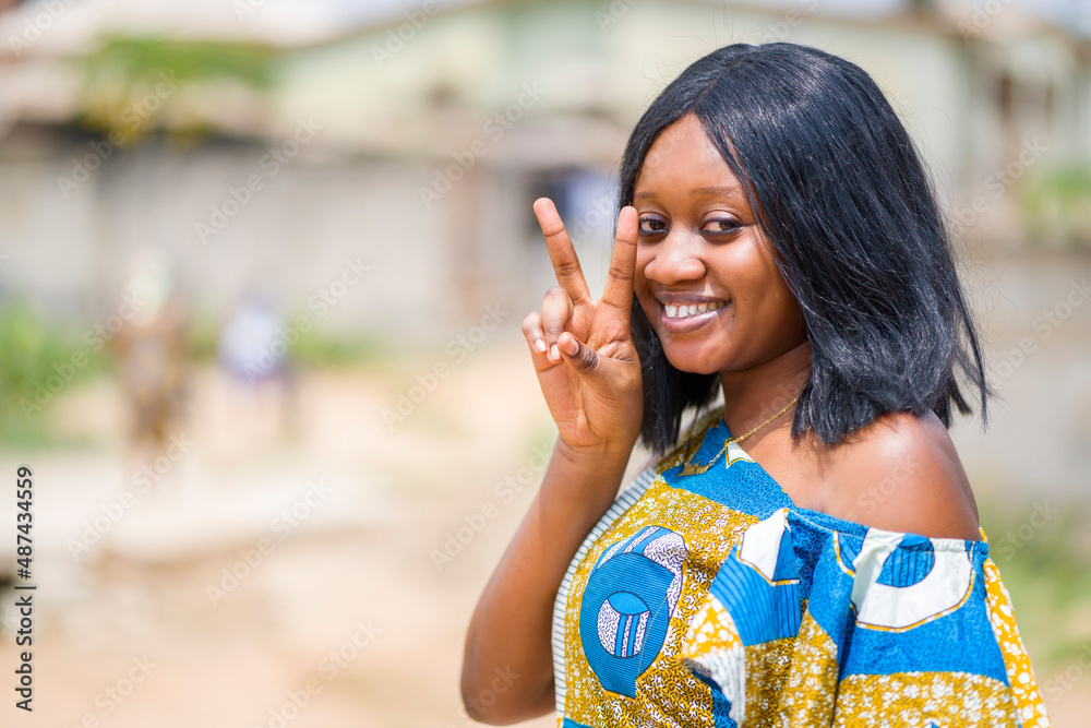 close up image of beautiful african lady with two fingers up, cheerful black woman out door close up image of beautiful african lady with two fingers up, cheerful black woman out door