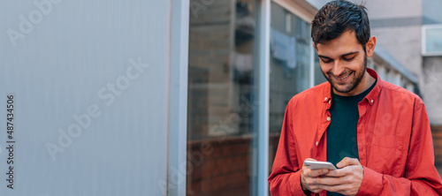 Quadro em tela urban style man using mobile or cell phone in the street outdoors