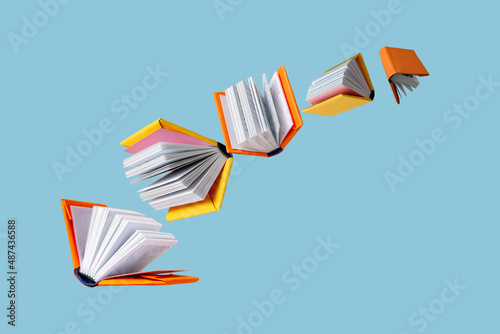 books in colored covers swirl on a blue background, copy space