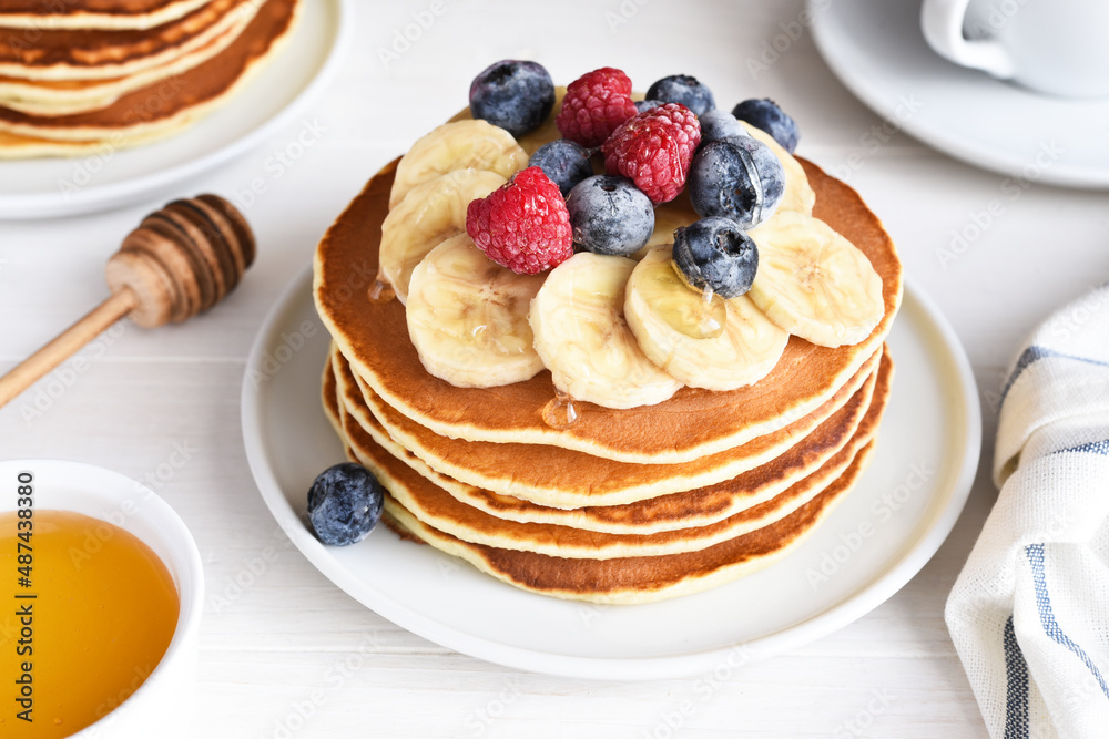 Stack of pancakes with berries and syrup on a kitchen table for breakfast. Good morning Stack of pancakes with berries and syrup on a kitchen table for breakfast. Good morning
