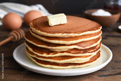 Blini or pancakes stack on wooden table with butter. Maslenitsa holiday concept. Rustic style breakfast