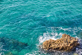 blue sea breaking on the rocks of the coast