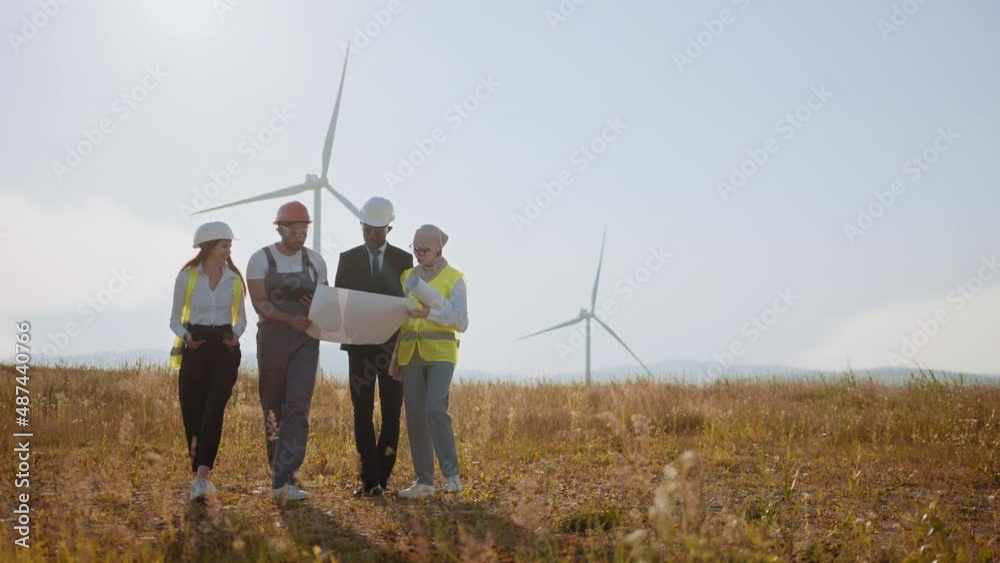 Businessman and team exploring the power generation area. Group of professionals cooperating for producing clean eco friendly energy. Engineers explores future wind turbine installation projects Businessman and team exploring the power generation area. Group of professionals cooperating for producing clean eco friendly energy. Engineers explores future wind turbine installation projects