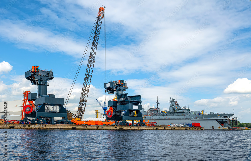 Hafenanlagen mit Trockendock, Kränen und Kriegsschiff in Wilhelmshaven