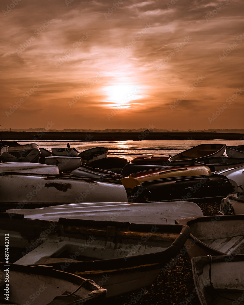Overturned boats in front of summer sunset at Felixstowe Ferry