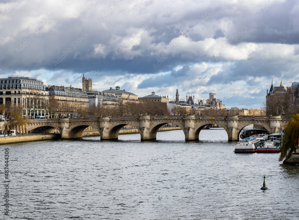 Seine embankment in Paris. View of the island of Cite and the bridge of Neuf. Beautiful breathtaking cityscape of the majestic famous ancient French city.
