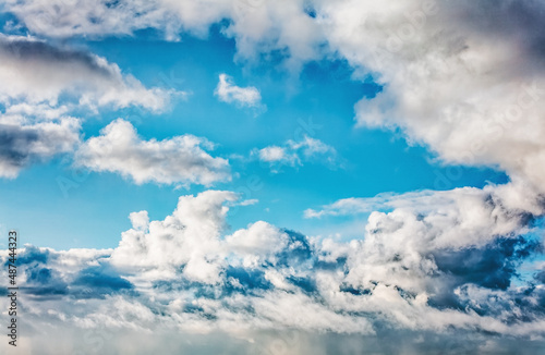 Daytime blue sky Background with white cumulus and tiny clouds. Soft focus. © Photobes