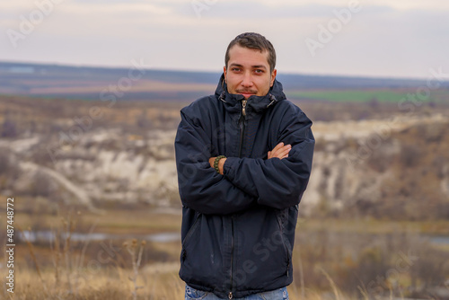 man or an adult guy a tourist or a hiker in a windbreaker is freezing from the cold. Background with copy space