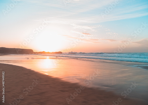 sunset on the beach with black rocks © Nelson