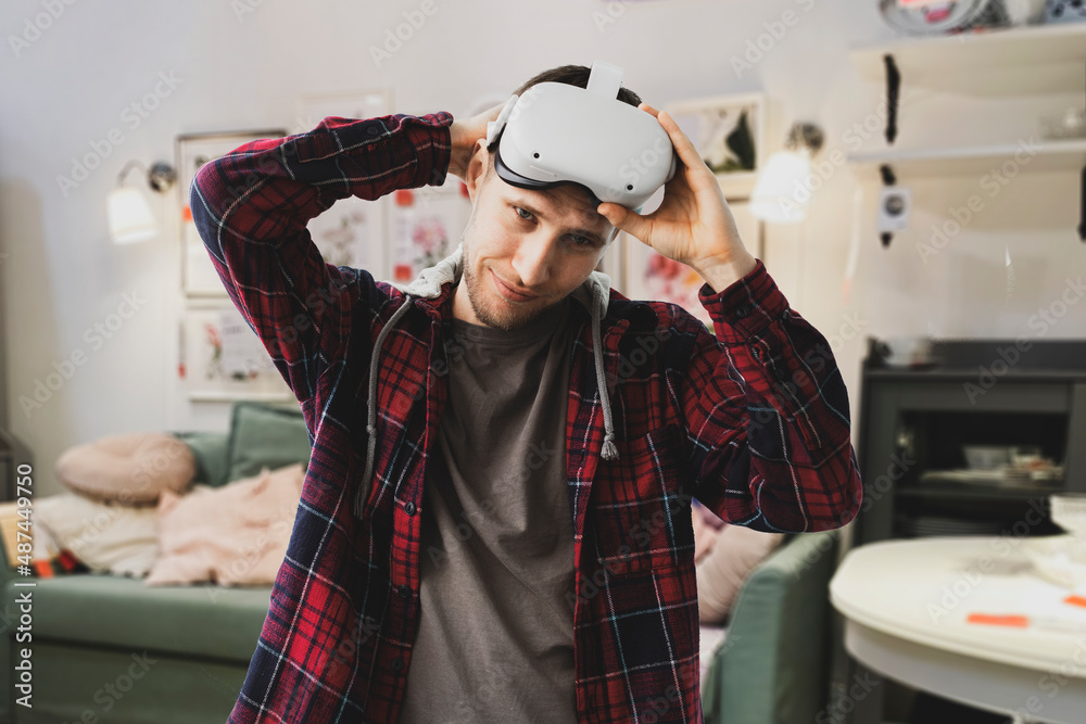 young male guy puts on his head virtual reality headset young male guy puts on his head virtual reality headset