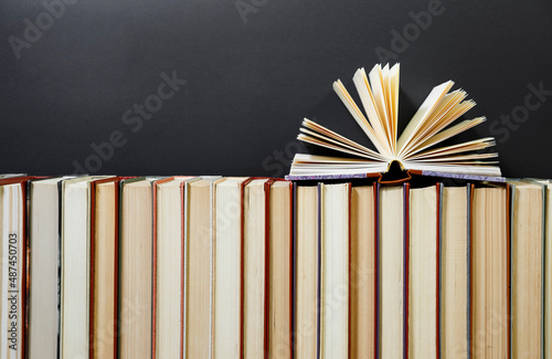 Composition with vintage old hardback books, diary, fanned pages on wooden deck table
