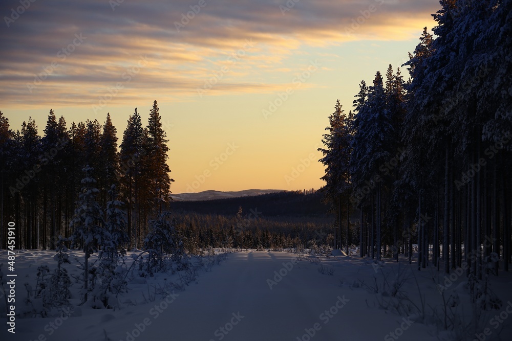 Sunset in nordic winter landscape with a snowy road Sunset in nordic winter landscape with a snowy road
