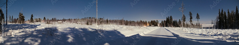 Fototapeta premium Night panorama of small Swedish town and road in winter, the town name Granbergsliden is written on the sign