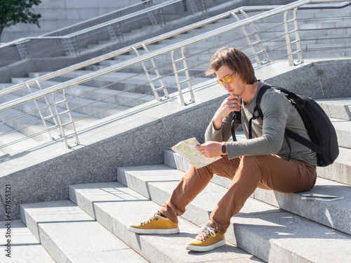 Canvas Print Man sits on stone staircase and reads map
