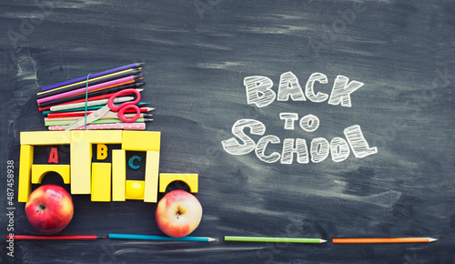 back to school background with black chalk board and school suppilents photo