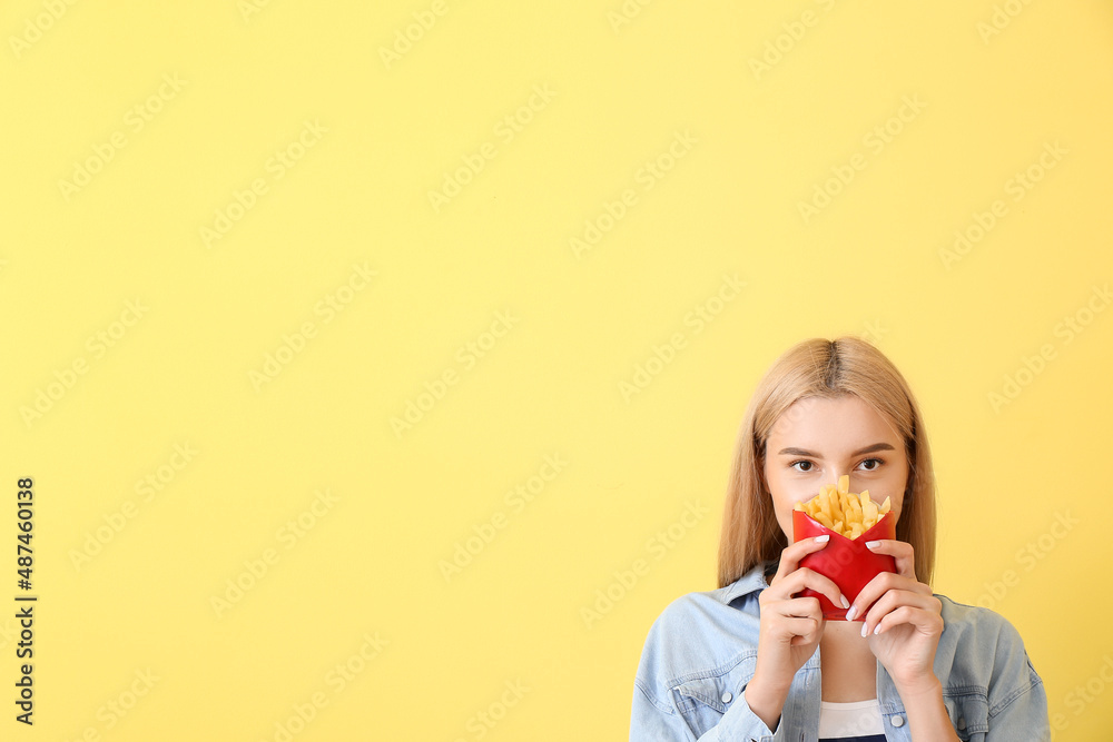 Young woman with french fries on yellow background Young woman with french fries on yellow background