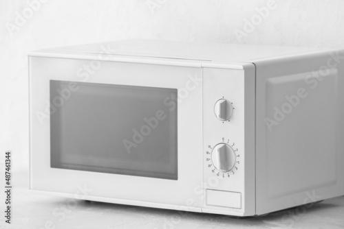 Modern microwave oven on light background