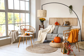 Interior of modern living room with comfortable sofa, lamp and armchairs