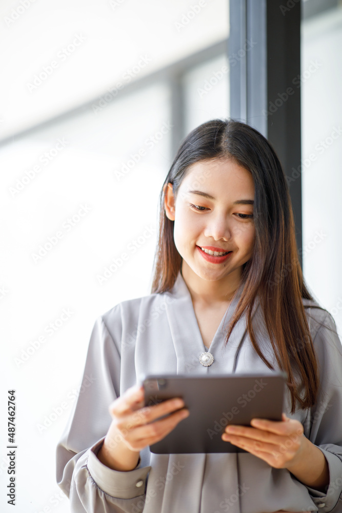 Excited happy Asian Young woman looking at the tablet screen, celebrating an online win, overjoyed young asian female screaming with joy, isolated over a white with background Excited happy Asian Young woman looking at the tablet screen, celebrating an online win, overjoyed young asian female screaming with joy, isolated over a white with background