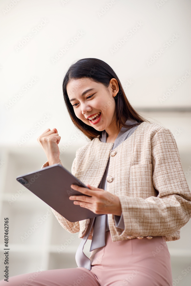 Excited happy Asian Young woman looking at the tablet screen, celebrating an online win, overjoyed young asian female screaming with joy, isolated over a white with background Excited happy Asian Young woman looking at the tablet screen, celebrating an online win, overjoyed young asian female screaming with joy, isolated over a white with background