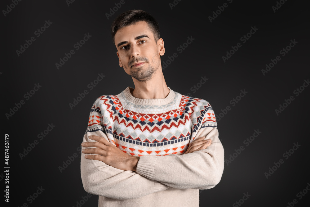 Handsome young man in knitted sweater on dark background Handsome young man in knitted sweater on dark background