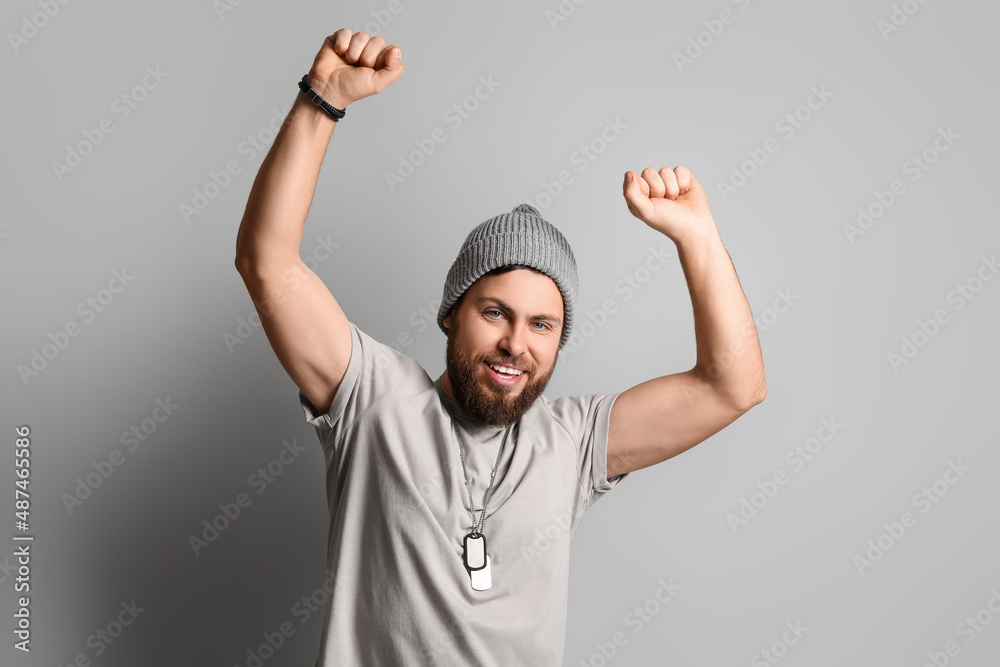 Fototapeta premium Stylish happy bearded man on grey background