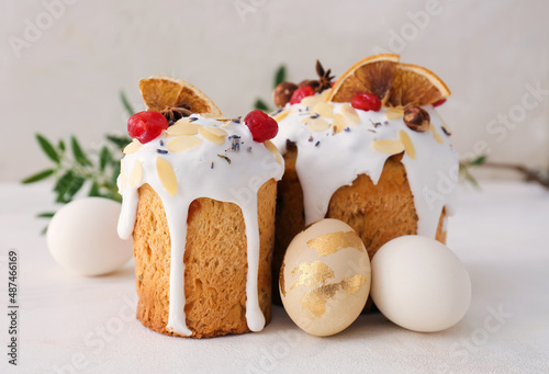 Delicious Easter cakes and eggs on light background photo