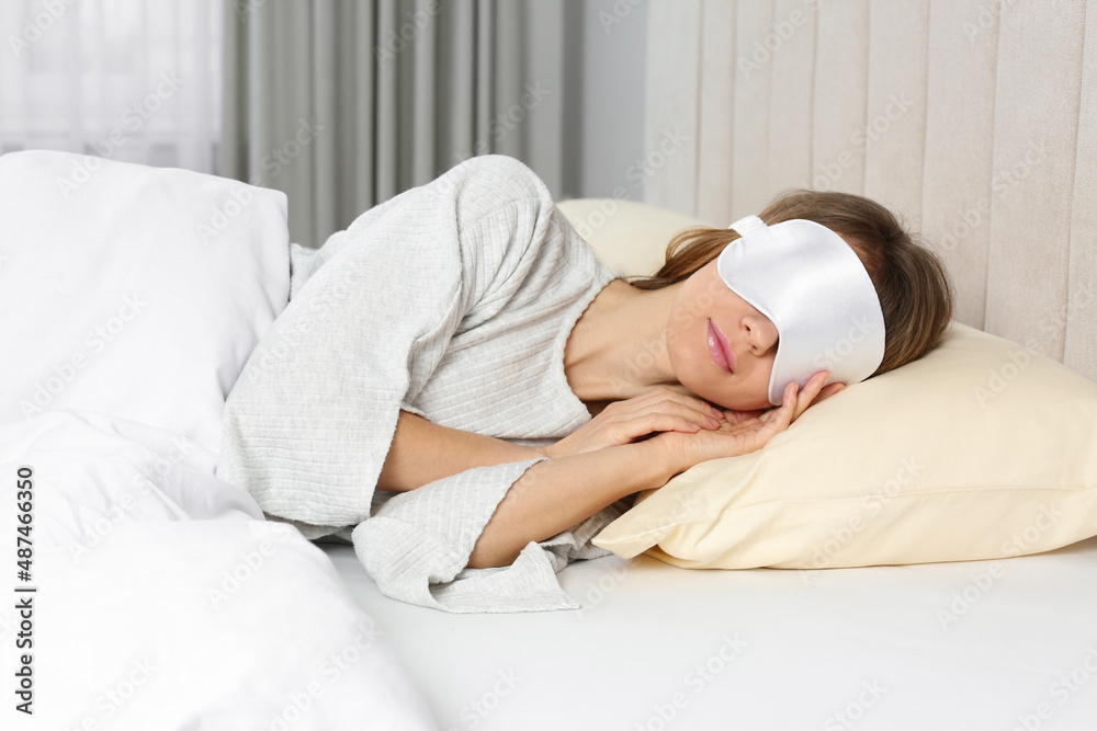 Woman with sleep mask in bed at home Woman with sleep mask in bed at home