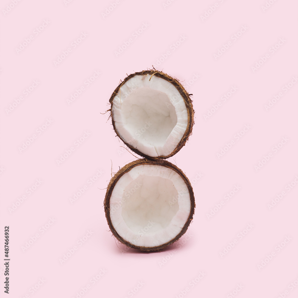 Organic opened two parts of the coconut head against a baby pink background at the top of each other. Fresh fruit, nut and seed concept. Organic opened two parts of the coconut head against a baby pink background at the top of each other. Fresh fruit, nut and seed concept.