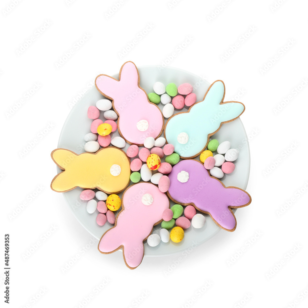 Plate with delicious Easter cookies in shape of bunny and candies on white background Plate with delicious Easter cookies in shape of bunny and candies on white background
