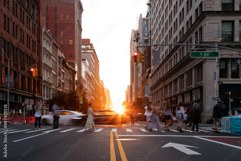 Diverse crowd of women and men walking across a busy intersection on 5th Avenue in New York City